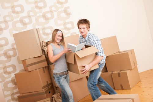 Professional movers carrying furniture on a residential street in St Johns Wood